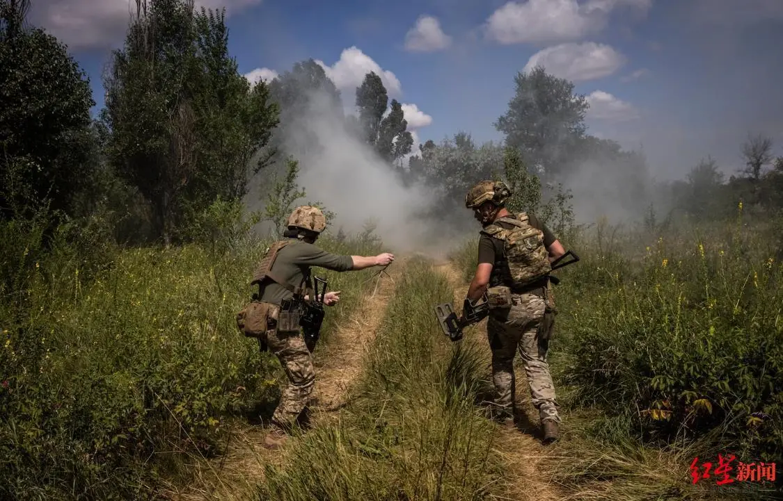 上周在乌克兰地区的一次训练演习中，士兵们准备用绳子拆除一枚反坦克地雷的雷管 ...